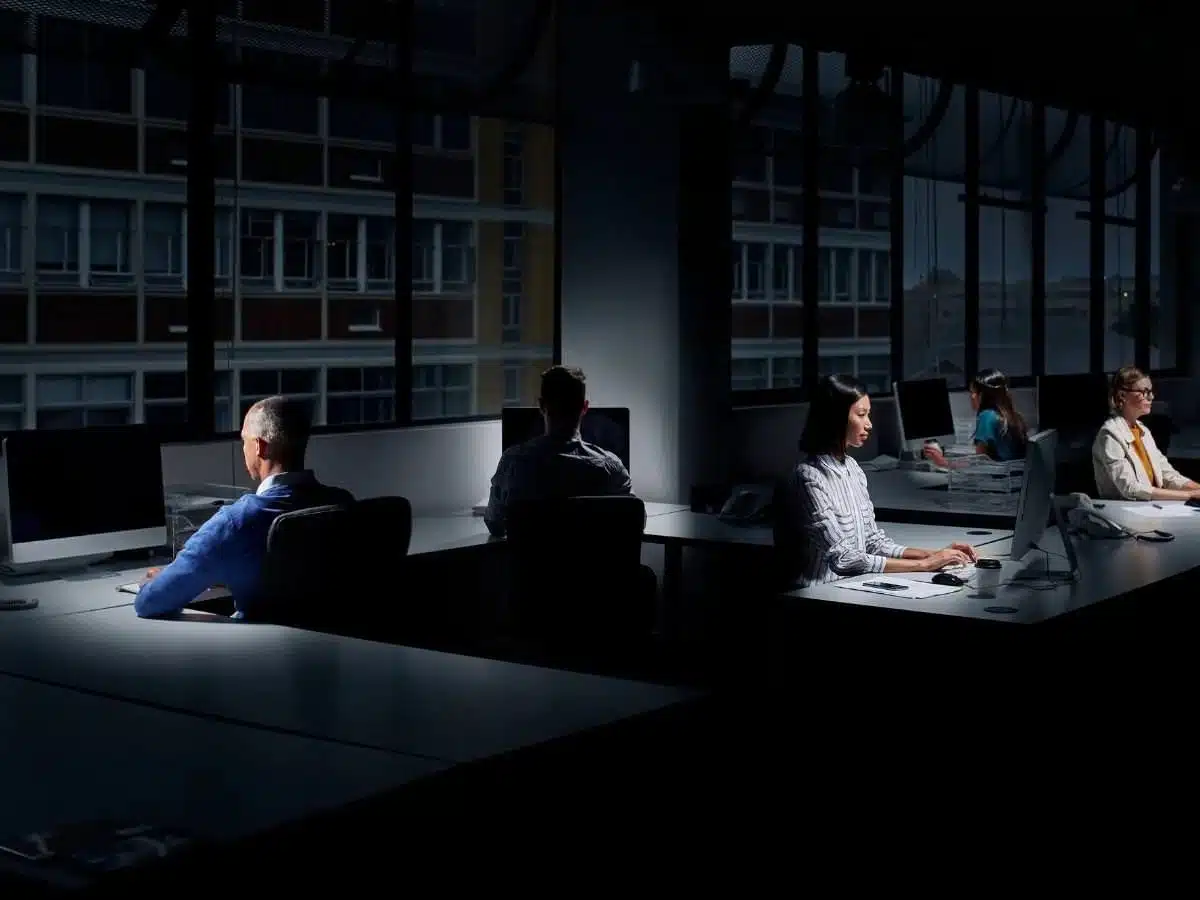 Image of low light office, employees in dark room